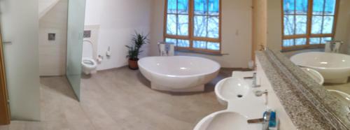 a large bathroom with two sinks and two toilets at Bed & Bike in Trichtingen