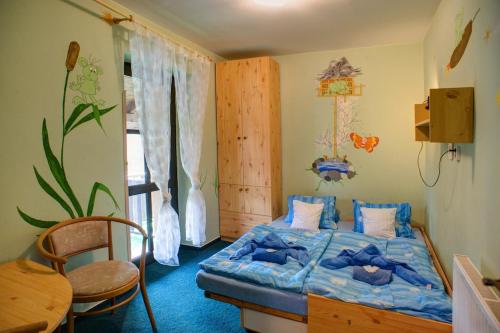 ein Schlafzimmer mit einem Bett, einem Tisch und einem Stuhl in der Unterkunft Borovansky mlyn in Borovany