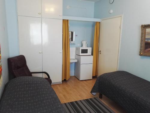 a small room with a bed and a microwave at Guesthouse Outa in Rovaniemi