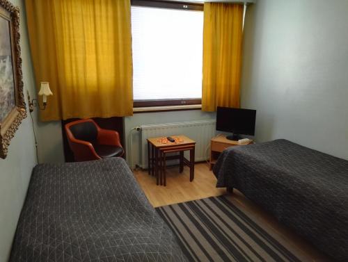 ロヴァニエミにあるゲストハウス オウタのベッドルーム1室(ベッド2台、テレビ、窓付)