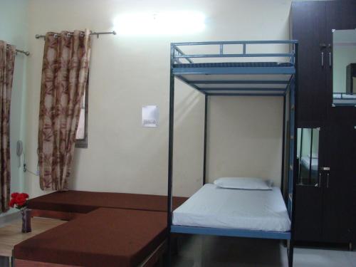 a bedroom with a bunk bed and a table at Hotel Abhinandan Grand in Dehradun