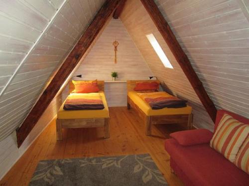 a attic room with two beds and a couch at Ferienhof Seeber in Weikersheim