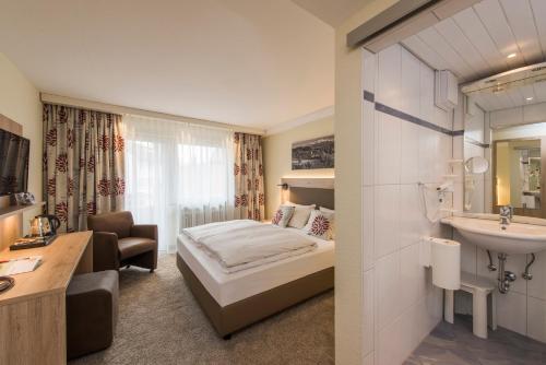 ロットヴァイルにあるHotel Bärenのベッドとシンク付きのホテルルーム