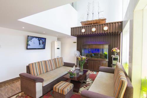 a living room with two couches and a fish tank at Ngoc Linh Luxury Hotel in Vung Tau