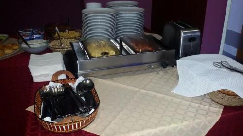 a table with a buffet with plates and a basket of food at Hotel Veleka in Chernomorets