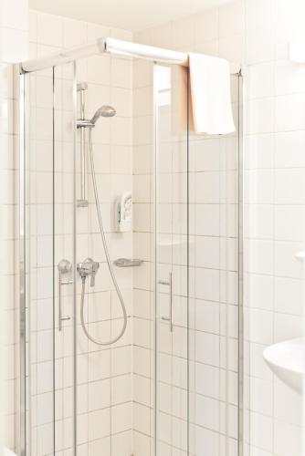 a bathroom with a shower with a glass door at Schweiger's Landgasthof in Wartenberg