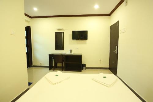 Habitación grande con lavabo y espejo. en Motel La Grandeur, en Mapusa