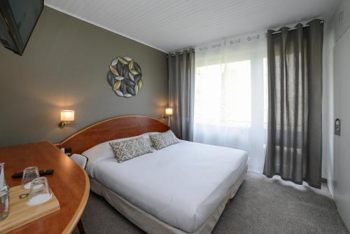a bedroom with a bed and a table and a window at Novalaise Plage in Novalaise