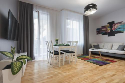 a kitchen and living room with a table and chairs at Millennium Awangarda Grey in Warsaw