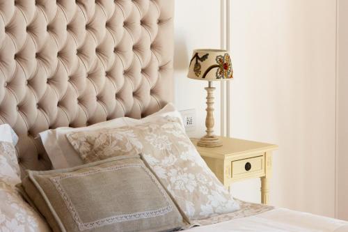 a bed with a large padded headboard and a lamp at Quinta do Fontelo in Vouzela