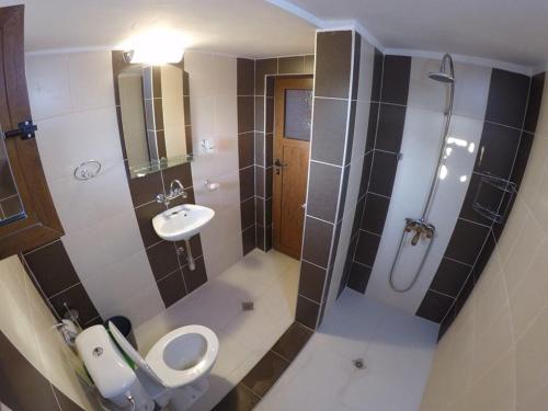 a bathroom with a toilet and a sink and a shower at Prostor Guest House in Byala