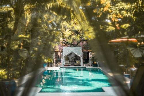 a view of a swimming pool through trees at The Pavilion in Phnom Penh