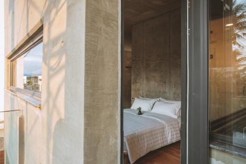 a bedroom with a bed next to a window at 墾丁 住在Zhuzai in Checheng
