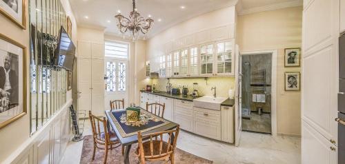 a kitchen with a table and chairs and a chandelier at VIP Residence Riverside in Budapest