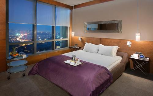 a hotel room with a bed and a large window at Point Hotel Barbaros in Istanbul