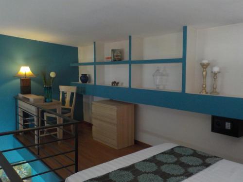 a bedroom with blue walls and a bed and a desk at Mary's Place Stalis in Stalida