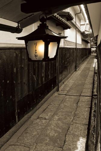 a street light hanging from a fence next to a sidewalk at Okayama Koraku Hotel in Okayama