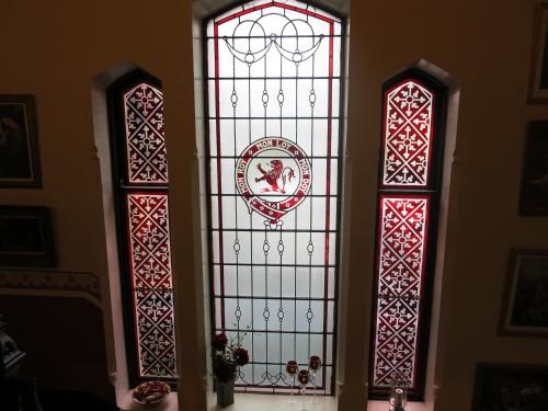 two stained glass windows in the corner of a room at Pitlochry Dundarach Hotel in Pitlochry