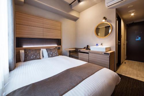 a bedroom with a large bed and a sink at S-Peria Hotel Hakata in Fukuoka