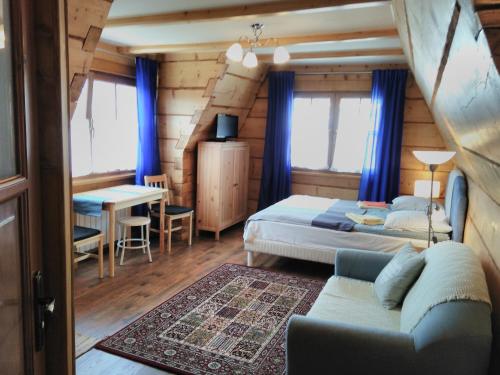 a bedroom with two beds and a table and a couch at Willa Baśka in Zakopane