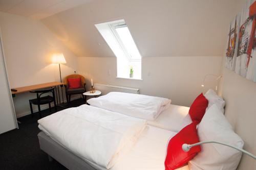 a bedroom with two white beds and a skylight at Benniksgaard Anneks in Gråsten