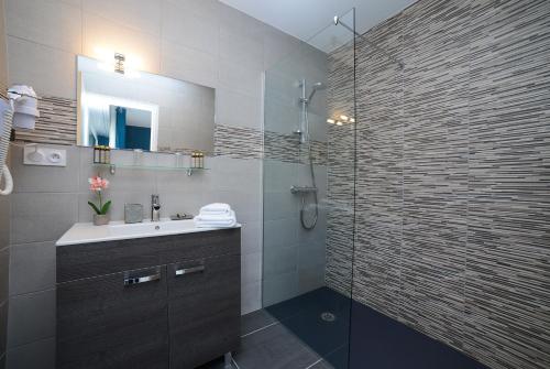 a bathroom with a sink and a glass shower at Novalaise Plage in Novalaise