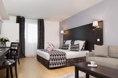 une chambre d'hôtel avec un lit sur lequel est allongée une personne dans l'établissement Seven Urban Suites Nantes Centre, à Nantes