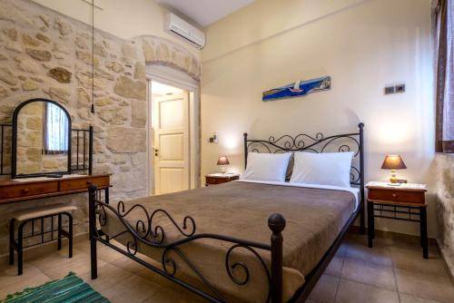 a bedroom with a bed and a desk and a mirror at Akrolithos Apartments in Ierapetra