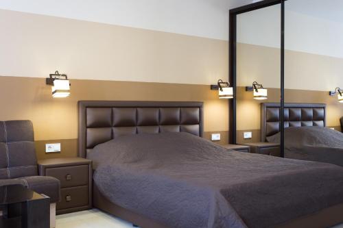 a bedroom with a bed and a large mirror at Luxury Studios on Nauki Avenue in Kharkiv