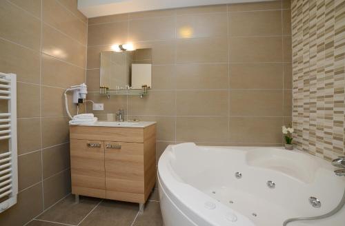 a bathroom with a tub and a sink and a mirror at Novalaise Plage in Novalaise