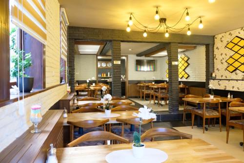 a restaurant with wooden tables and chairs and a chandelier at Hotel im Anker in Hannoversch Münden