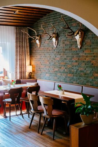 a restaurant with tables and chairs and a brick wall at Hotel-Restaurant Fuchs in Handeloh