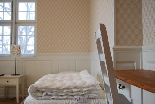 a bedroom with a bed and a desk and windows at Halmstad Hotell & Vandrarhem Kaptenshamn in Halmstad