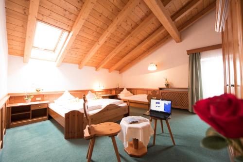 a room with two beds and a laptop in it at Villa Rier in Siusi