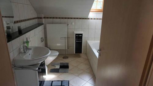 a bathroom with a sink and a toilet and a tub at s'Heisl em Woid in Bad Koetzting