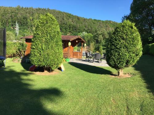 a yard with two trees in front of a cabin at Ferienwohnung Hankel in Hemfurth-Edersee