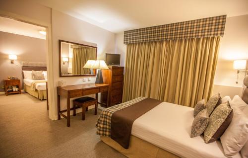 a hotel room with a bed and a desk at Stirling Court Hotel in Stirling