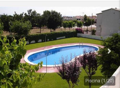 a swimming pool in the middle of a yard at Casa _pareada con piscina y jardin privado in Torredembarra