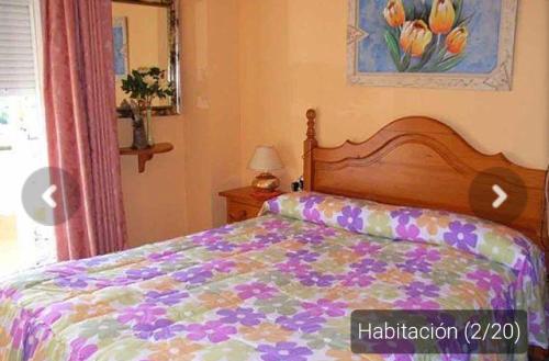 a bedroom with a bed with a colorful comforter at Casa _pareada con piscina y jardin privado in Torredembarra