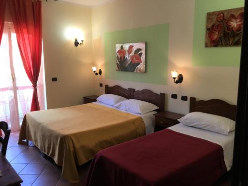 Habitación de hotel con 2 camas y ventana en Il Melograno en Nicotera Marina