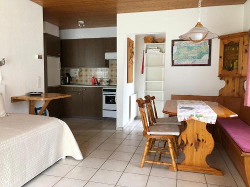 eine Küche und ein Wohnzimmer mit einem Tisch und einem Bett in der Unterkunft Almis Sunna in Grindelwald