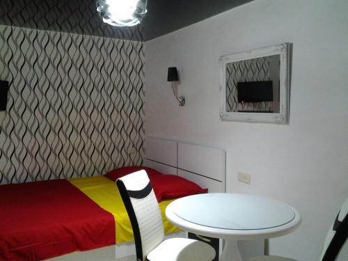 Cette chambre comprend une table, un lit, une table et une chaise. dans l'établissement Anna's Apartment, à Batoumi