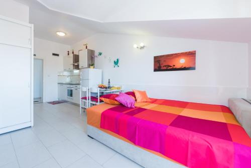 1 dormitorio con 1 cama colorida y cocina en Apartment Yellow Story, en Vodice