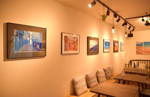 a restaurant with tables and pictures on the wall at IZA Enoshima Guest House and Bar in Fujisawa