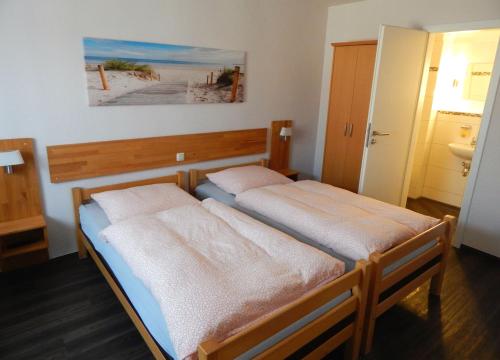 een slaapkamer met 2 bedden in een kamer bij Pension am Burgwall in Wismar