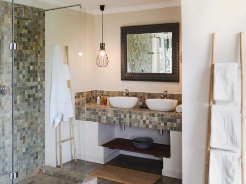 a bathroom with two sinks and a shower at Simbavati River Lodge in Timbavati Game Reserve