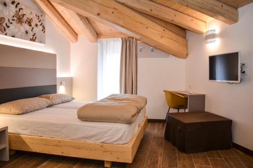 a bedroom with a bed and a desk and a television at Theresia in Riva del Garda
