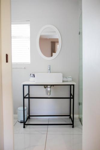 a bathroom with a sink and a mirror at Elianthe Guesthouse in Swellendam