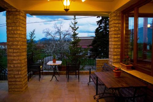 a patio with a table and chairs and a window at Hotel Odysseas in Kalyvia