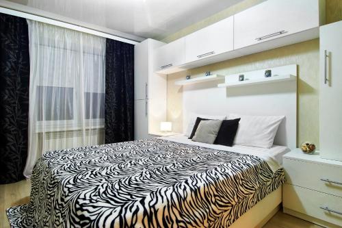 a bedroom with a zebra print bed in a room at PaulMarie Apartments on Kozhara in Gomel
